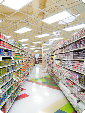 Grocery store aisle with stocked shelves and colorful floor.
