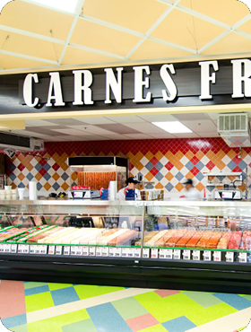 Meat counter in a grocery store with a CARNES FRESCAS sign above it