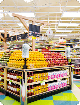 Grocery store produce section with stacked fruits and juice cartons